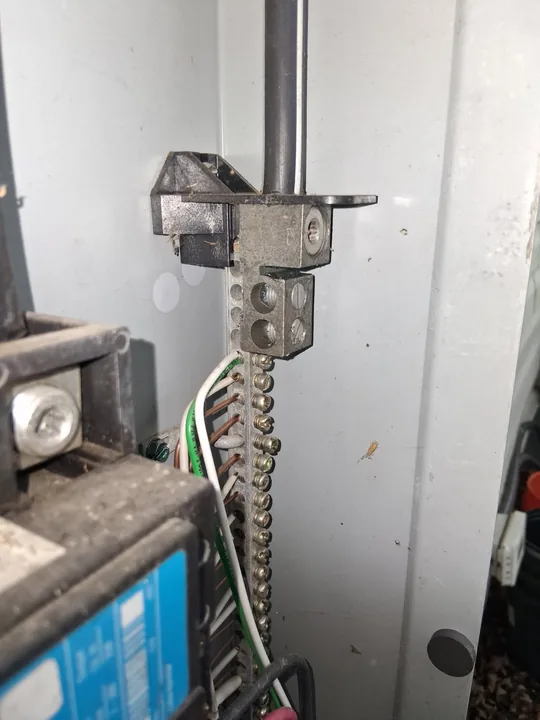 Neutral and ground terminal bus connections inside an electrical panel