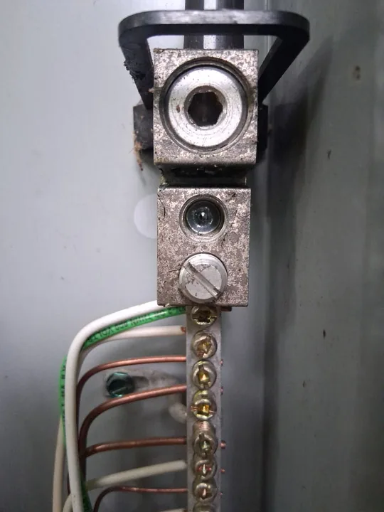 Close view of terminal lugs and grounding conductors inside an electrical panel
