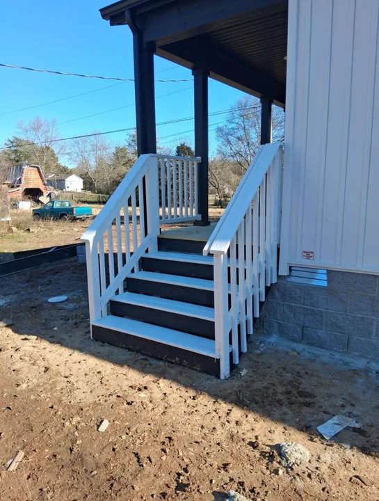 Painted exterior entry stairs with white railings and blue-gray treads