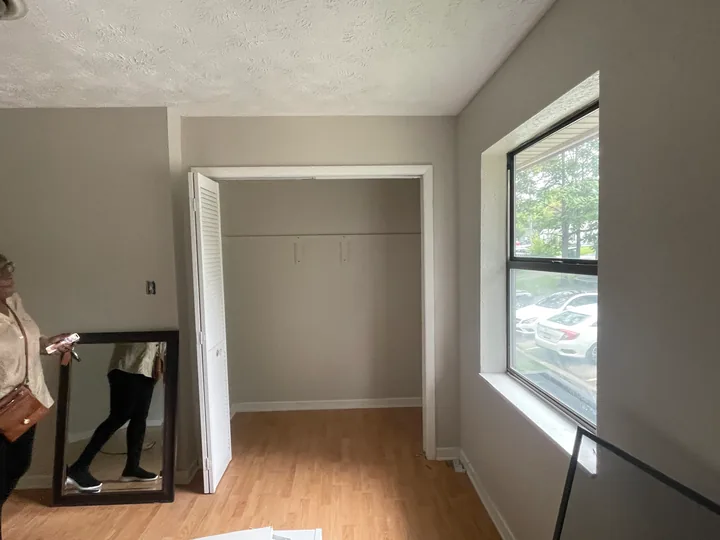 Painted room with white window trim, baseboards and wood flooring