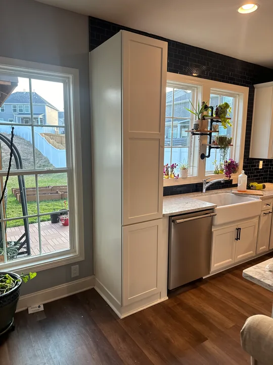Painted walls and white window trim beside a kitchen
