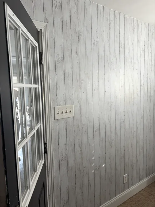 Existing paneled wall beside the garage entry before the pantry build-out.