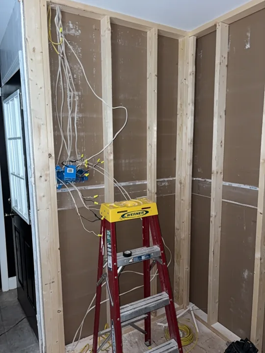 New pantry wall framing with the relocated switch box visible before drywall.