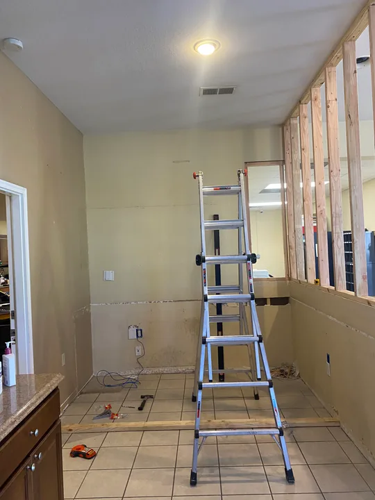 Partition framing and ceiling lights beside an existing counter
