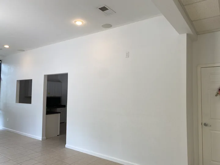 Painted partition wall and openings beside a tiled commercial floor
