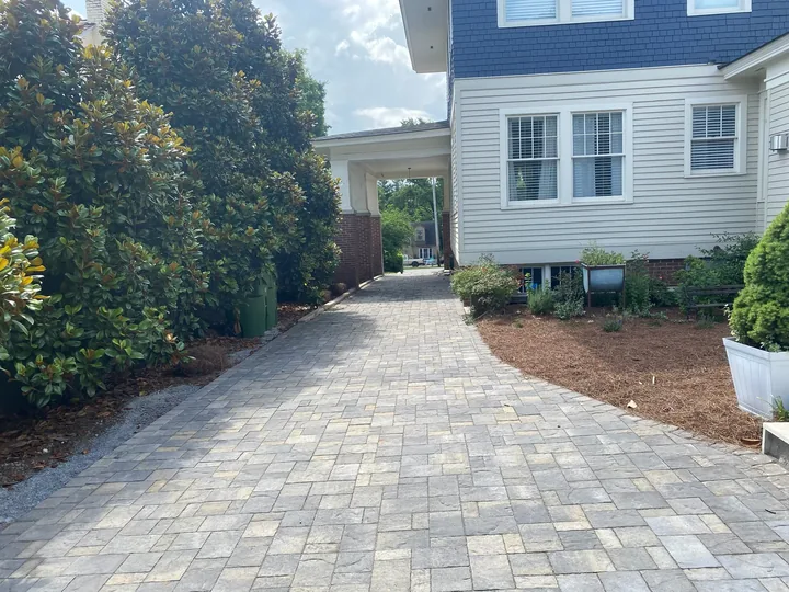 Curved paver driveway and walkway beside a home