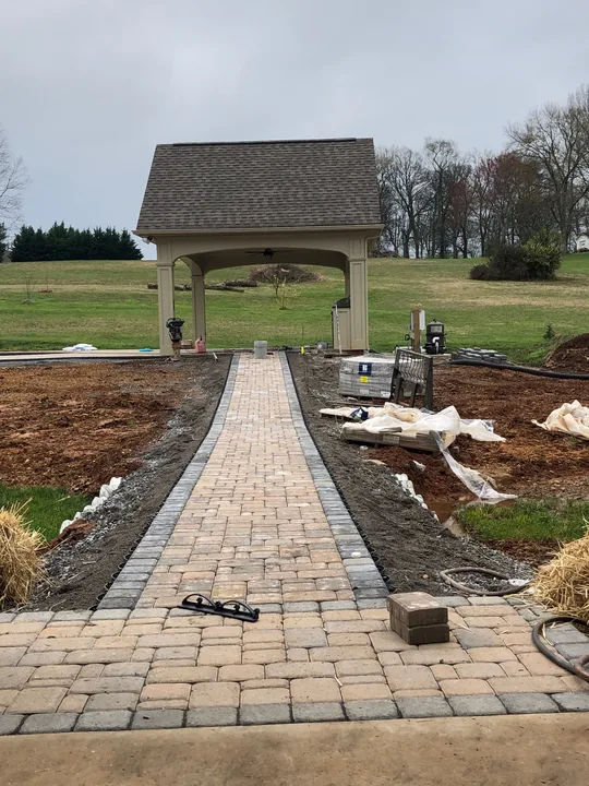 Curved paver driveway and walkway beside a home