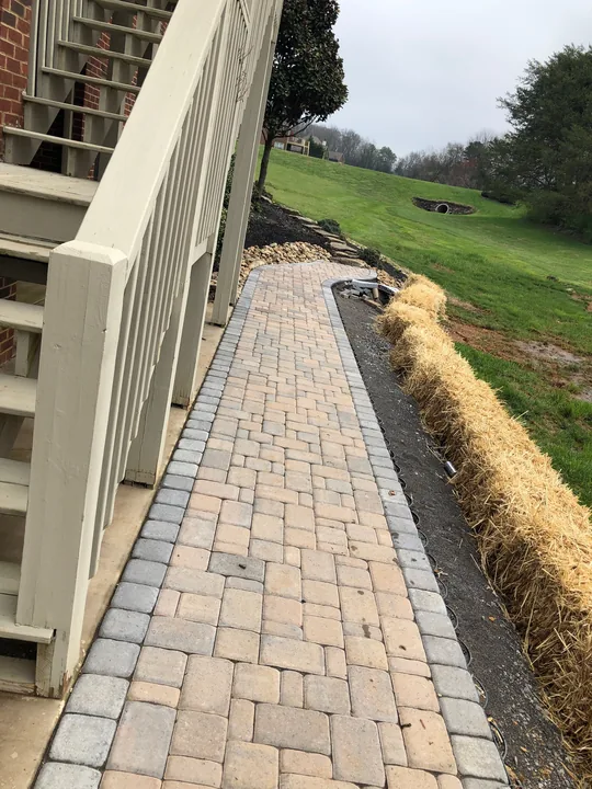Paver walkway and masonry steps beside a home
