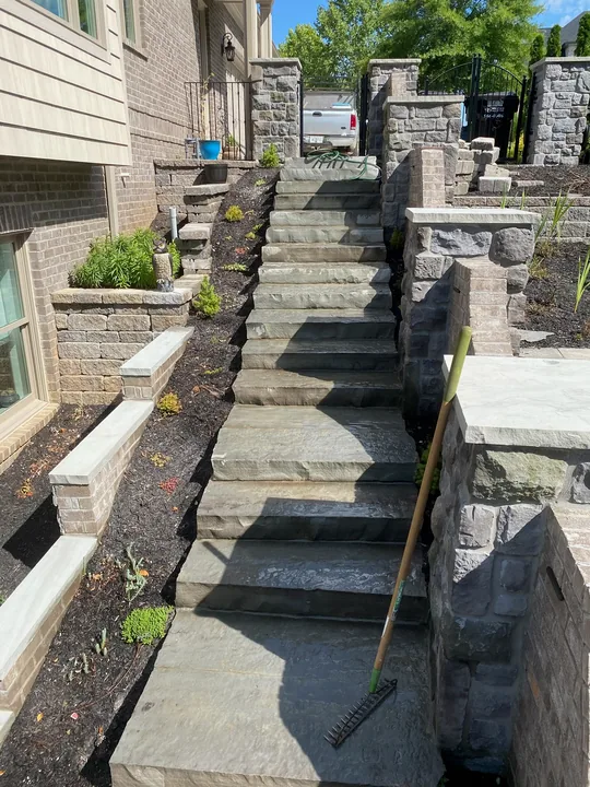 Paver walkway and masonry steps beside a home