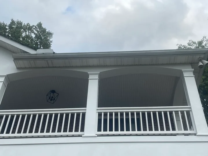 White porch columns, arches and railings on a two-story home