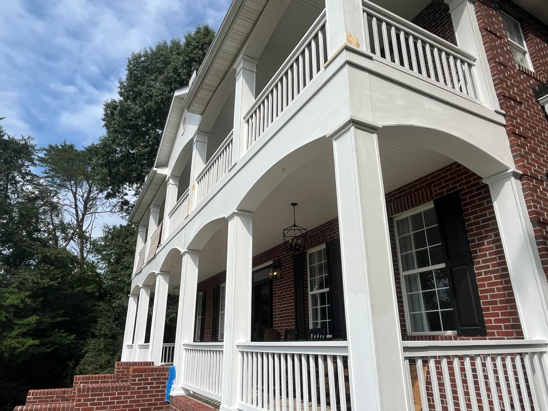 White porch columns, arches and railings on a two-story home