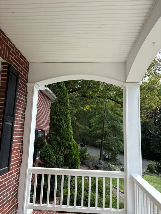 White porch columns, arches and railings on a two-story home