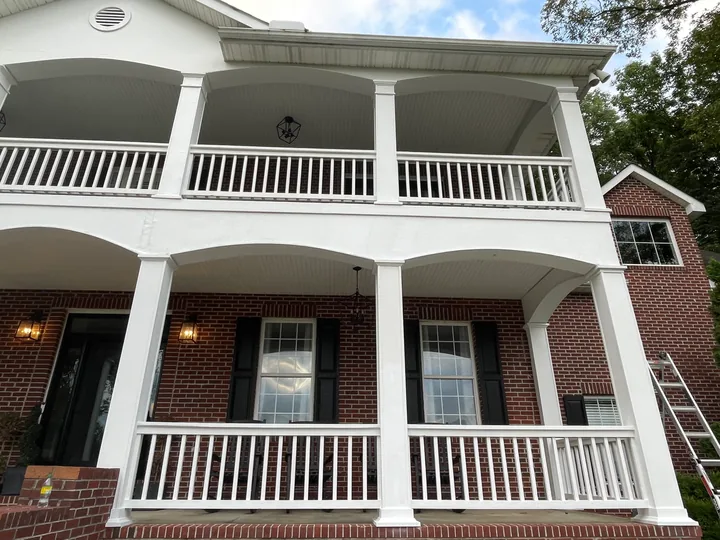 White porch columns, arches and railings on a two-story home