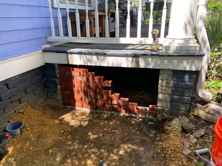 Masonry porch support and exposed repair area below a porch