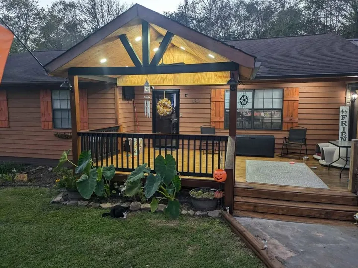Covered timber porch with railings and warm evening lights