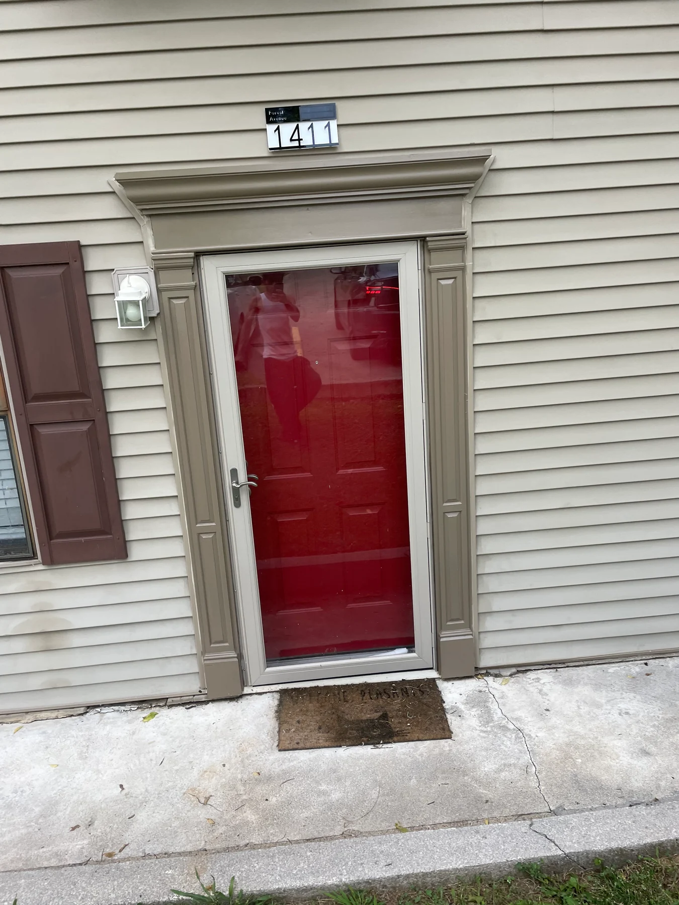 Red entry door with white casing and a light above the doorway
