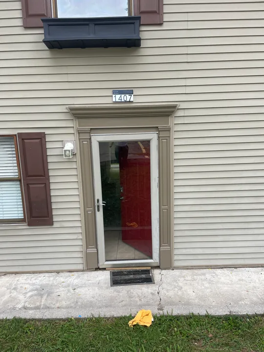 Red entry door with white casing and a light above the doorway