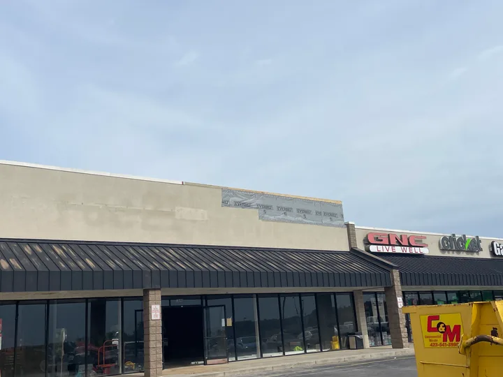 Retail facade and fascia above a dark storefront awning