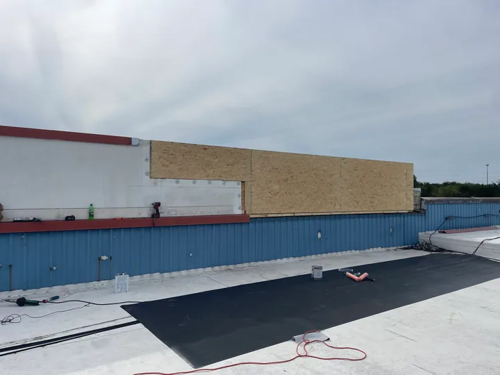 Retail facade and fascia above a dark storefront awning