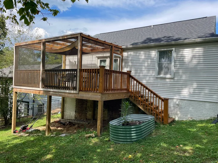 Timber steps, railing and screened porch beside a home