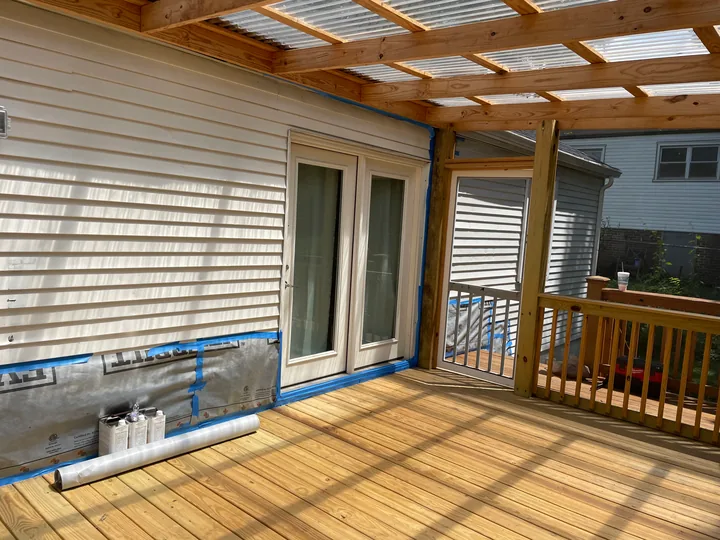 Timber steps, railing and screened porch beside a home