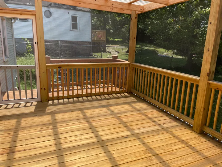 Timber steps, railing and screened porch beside a home