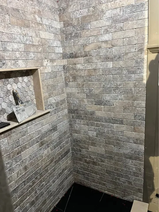 Stone-look shower tile, recessed niche and sliding shower door