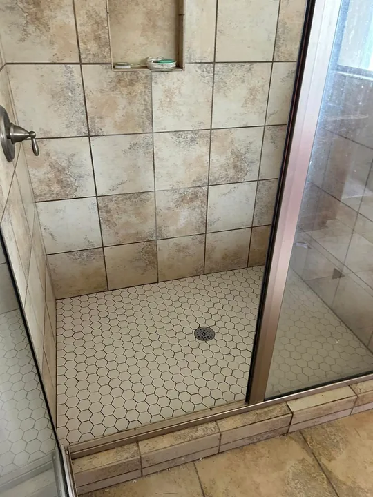 Stone-look shower tile, recessed niche and sliding shower door