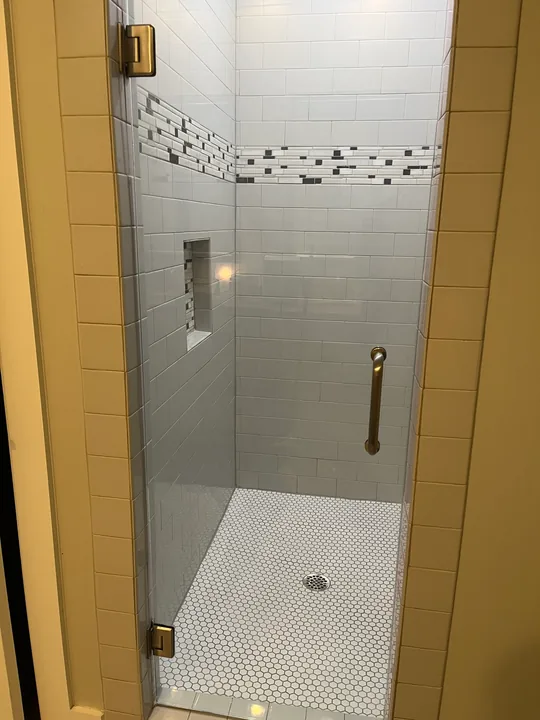 Tiled shower, patterned accent band and recessed shower light