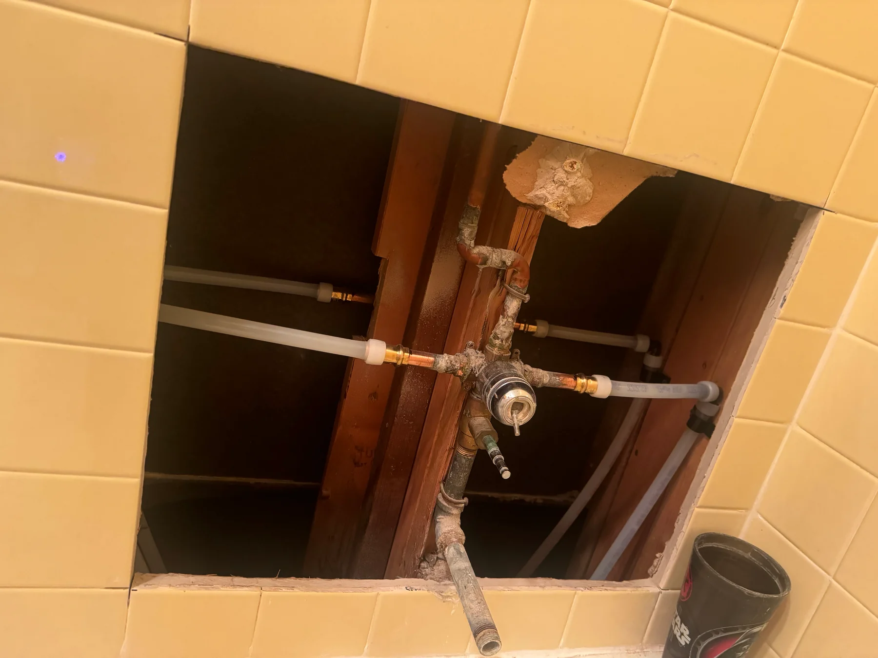 Open shower wall exposing the mixing valve and pipework