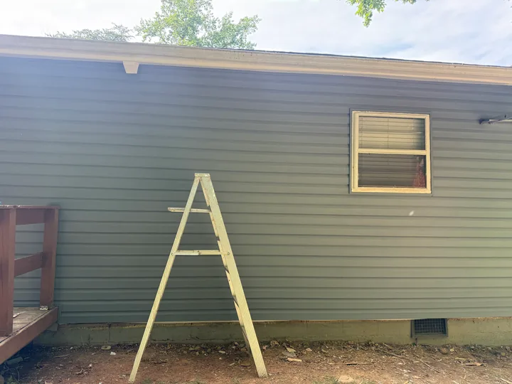 Exterior siding repair and wall framing beside a home