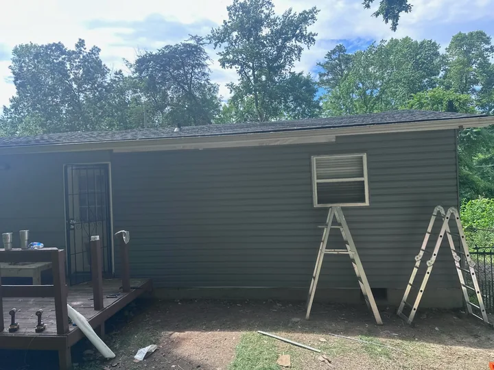 Exterior siding repair and wall framing beside a home
