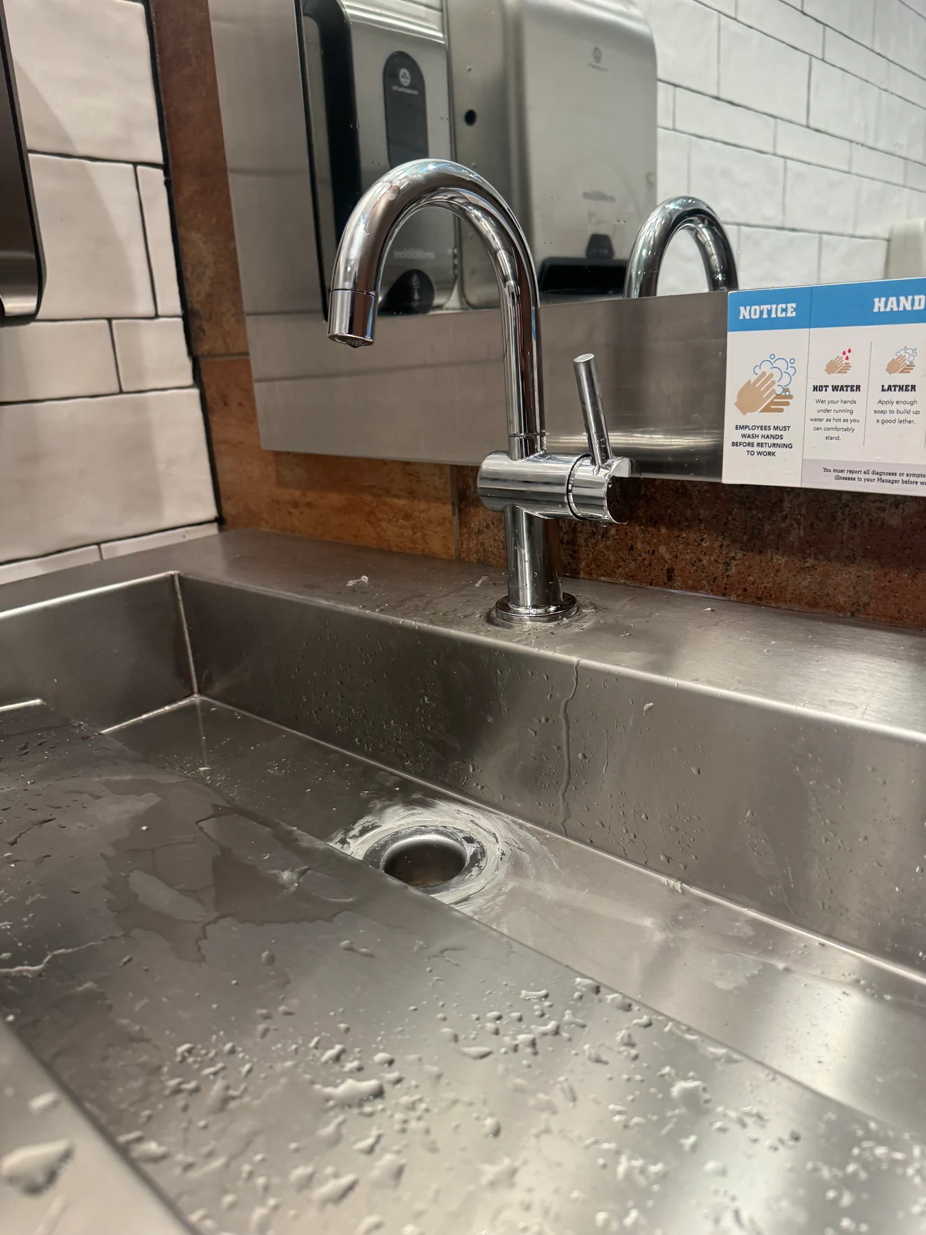 Stainless kitchen sink and pull-down faucet on a light countertop
