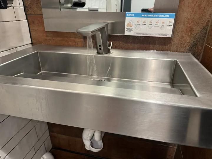 Stainless kitchen sink and pull-down faucet on a light countertop