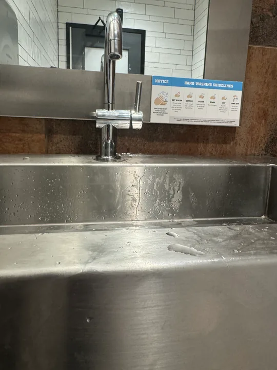 Stainless kitchen sink and pull-down faucet on a light countertop
