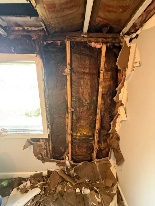 Exposed framing and wall removal during the sloped-ceiling room remodel
