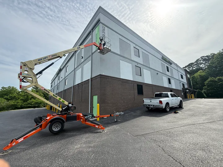 Boom lift alongside the Extra Space Storage building during exterior work