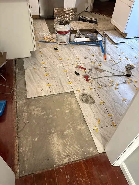 Exposed and replaced sheet subfloor beside room walls