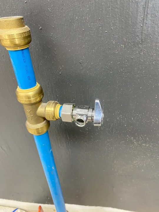 Fixture shutoff valve connected to a blue water supply pipe