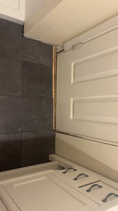 Tiled tub surround beside a white bathroom door