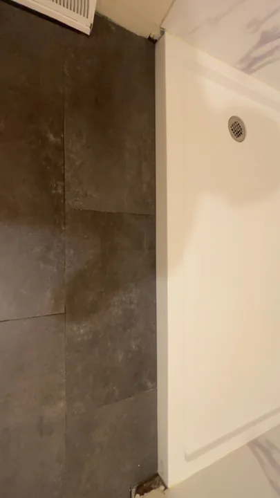 Tiled tub surround beside a white bathroom door