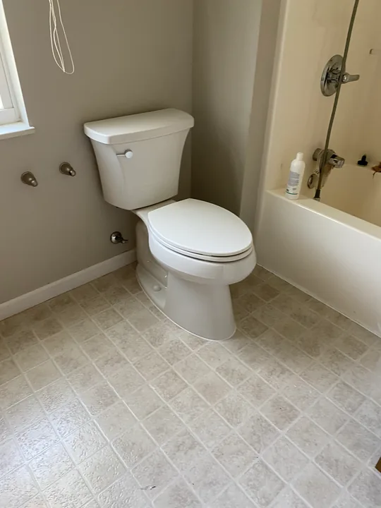 White toilet and nearby bathroom floor and wall clearance