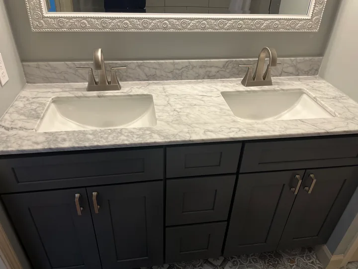 Bathroom vanity, framed mirror and light tile flooring