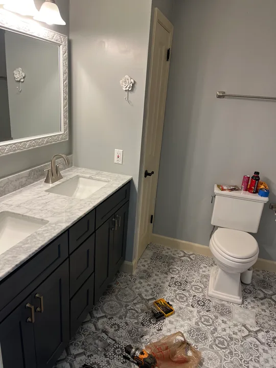 Bathroom vanity, framed mirror and light tile flooring