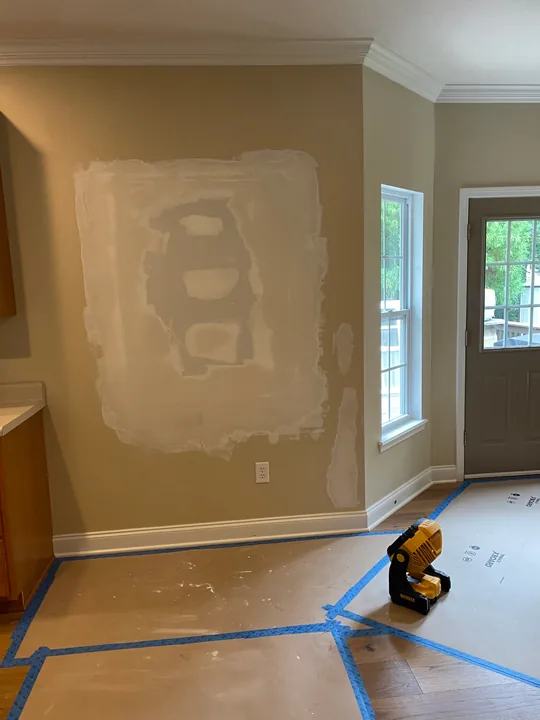Drywall patch, joint compound and protected flooring in a room