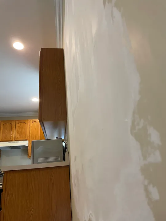 Drywall patch, joint compound and protected flooring in a room