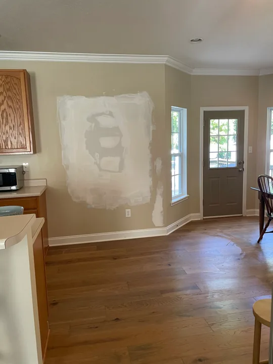 Drywall patch, joint compound and protected flooring in a room