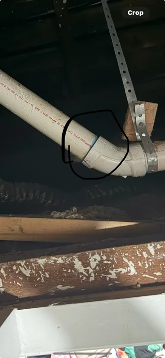 White waste pipes and connection fittings beneath a floor