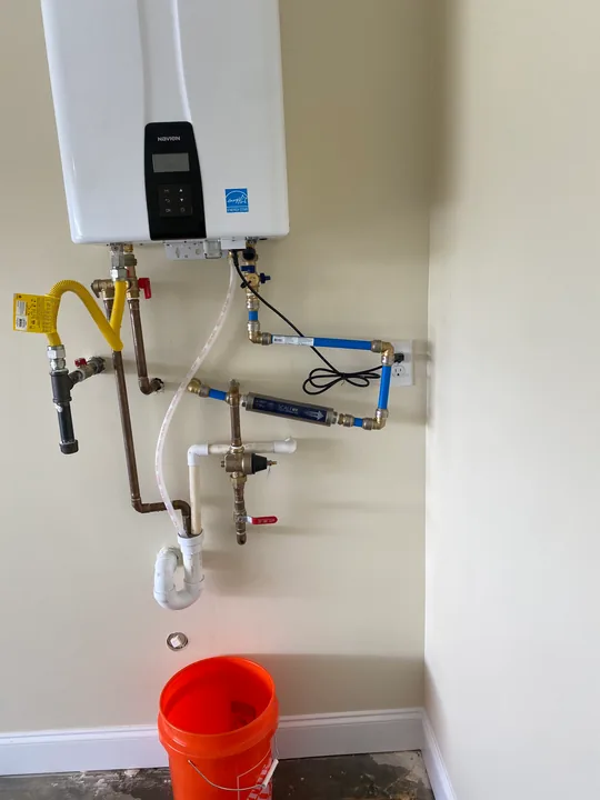 Wall-mounted tankless water heater and visible pipe connections