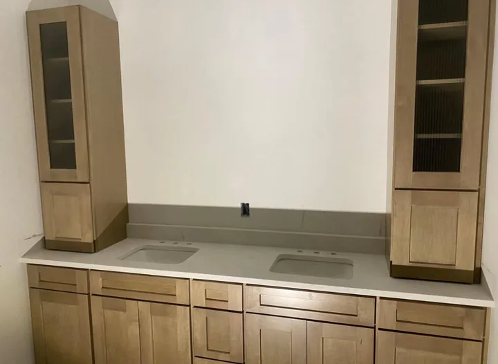 Wood kitchen cabinets and light countertops beneath wall cabinets
